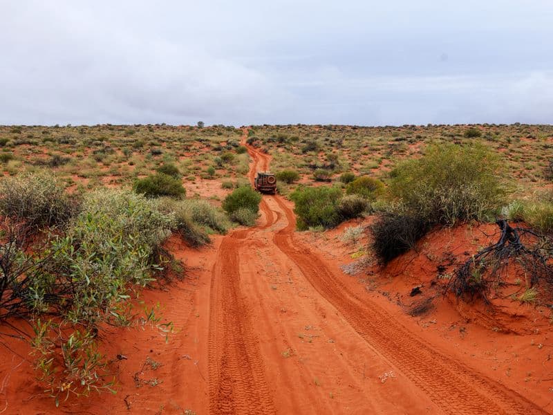 Off-road vehicle on a red dirt track in the Australian desert